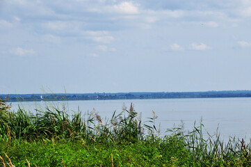 Panoramic view of the lake. Cloudy summer day. Before a thunderstorm on the lake. Thunderclouds.
