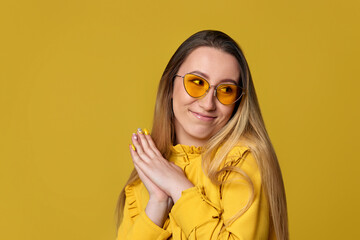 shy woman in sunglasses on yellow background.