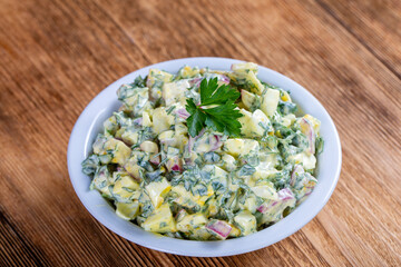 Salad of radish, boiled egg, parsley and sour cream in white bowl - healthy breakfast concept