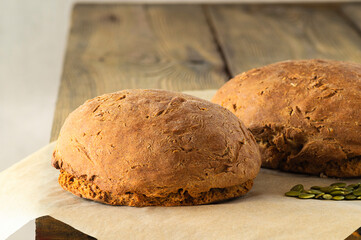 Two round, pumpkin bread rolls close-up with peeled pumpkin seeds. Healthy food, home-made bakery products. Close-up..