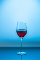Close up view of red wine in glass isolated on blue background. Sweden.