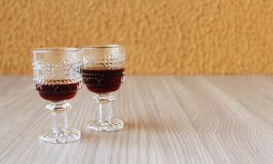 Duas pequenas taças de cristal ou vidro para bebida alcoólica sobre a mesa. Dose de licor, vinho, aperitivo.