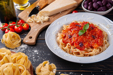 .Italian pasta dish with tomato sauce. Composition with ingredients for the preparation of the dish.