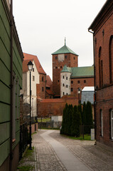 Fototapeta na wymiar Krotka Street with view of Castle of the Pomeranian Dukes, gothic architecture. Darlowo, Poland.