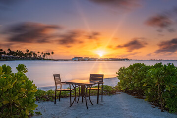 Outdoor restaurant with views of ocean and beautiful sky at sunrise. Crossroads Maldives, saii lagoon. Long exposure picture. July 2021