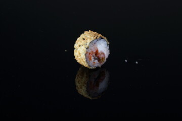 Roll with eel in tempura on a black background