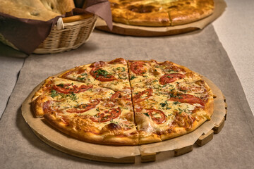 Ruddy pizza with red tomatoes on a wooden tray