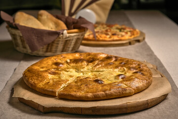 Ruddy closed pizza on a wooden tray