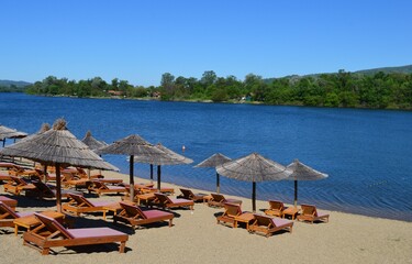 deck chairs and parasols on the lake shore