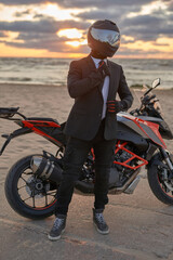 Fototapeta na wymiar Active businessman with modern sports motorbike on beach