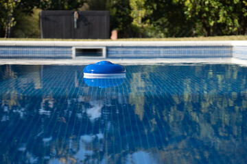 a pool chlorine dispenser floating in water