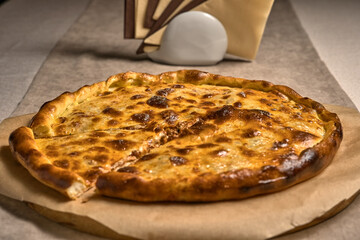 Ruddy closed pizza on a wooden tray