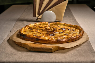 Ruddy closed pizza on a wooden tray