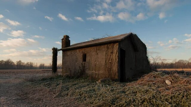 Cclouds mooving on a farmhouse in a field timelapse
