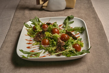 Fried meat with tomatoes and lettuce