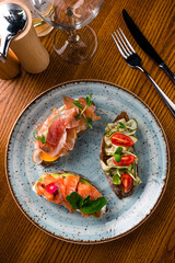 Italian cuisine. Three bruschettas with cheese, cherry tomatoes, basil, feta copy space text