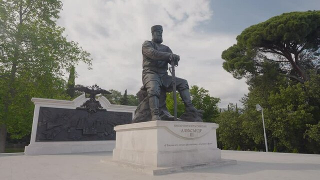Military monument to Russian Emperor. Action. Bronze statue of Alexander III in Crimean Park. Beautiful and warlike statue of Russian emperor in park