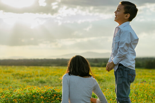 Hermano riendo de su hermana sentada 