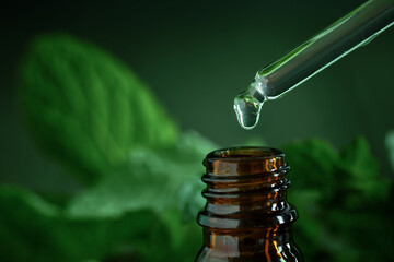 Dripping essential oil or serum from pipette, beauty care concept