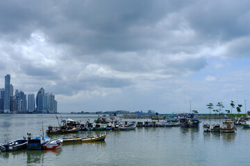 Fototapeta premium Small fishing boats in the seafood market of Panama with the skyline in the background