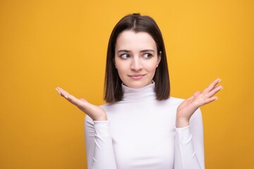 Close-up portrait of a surprised brunette on a yellow background