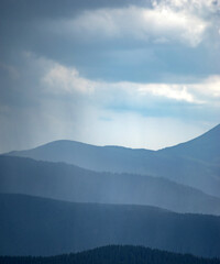 Sun rays and rain in the carpathian mountains in summer