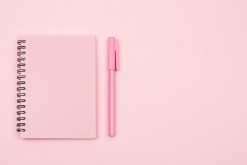 pink notebook and pink pen on a pink background