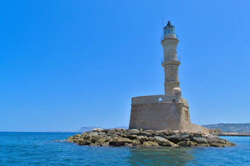 Fototapeta na wymiar Sea lighthouse in summer in sunny cloudless weather.