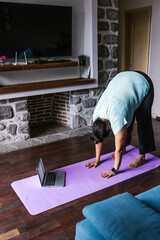 Young overweight hispanic woman with computer exercising at home in Mexico, plus size female