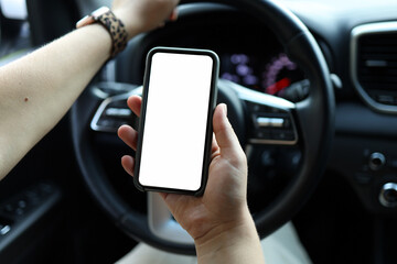 Mock up image, girl using blank white screen mobile smart phone inside a car in sunny day, touching...