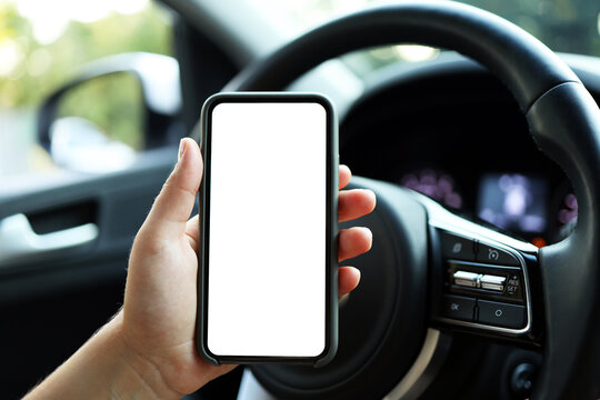 Mock up image, girl using blank white screen mobile smart phone inside a car in sunny day, touching screen or texting, copy space for your advertisement