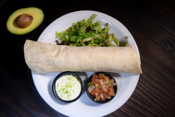 Burritos wraps with beef and vegetables on black background. Beef burrito, mexican food. Banner