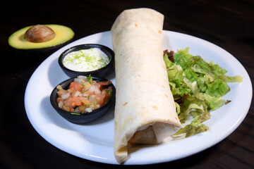 Burritos wraps with beef and vegetables on black background. Beef burrito, mexican food. Banner