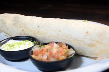Burritos wraps with beef and vegetables on black background. Beef burrito, mexican food. Banner