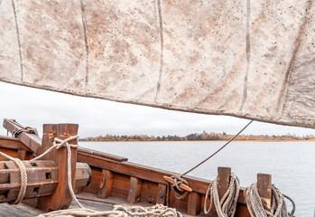 Wooden old ship in vintage style with all sails set in misty lake.