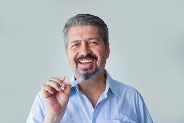 Close-up of a Adult Man Putting Transparent Aligner on His Teeth	