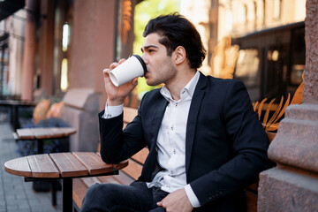 A successful entrepreneur works near the office. A broker drinks coffee in a cafe.