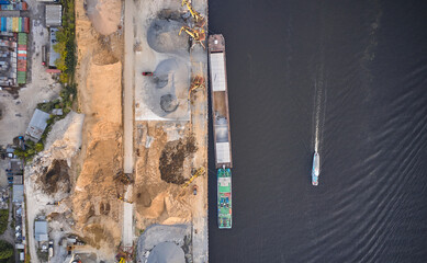 Aerial view of the vessels and harbour. Motorboat is moving through the river port