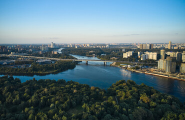 Naklejka premium Aerial of cityscape with a river and forest