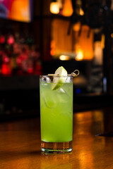 green lemonade with an apple in a dark bar