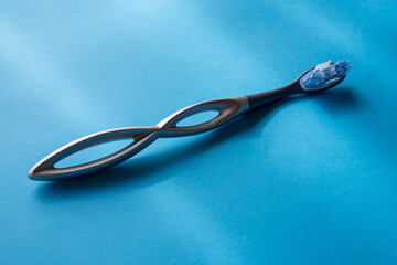 modern aluminum toothbrush on a light blue surface