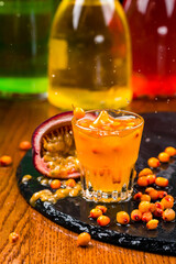 Homemade buckthorn soft drink in a glass and ripe sea buckthorn berries on the table
