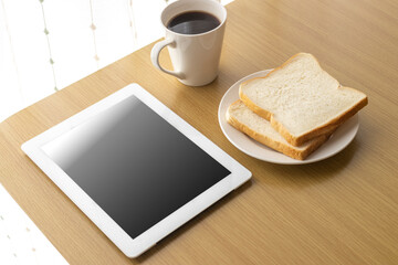 朝食を食べながら、タブレット端末を使う、イメージ