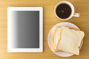  朝食を食べながら、タブレット端末を使う、イメージ