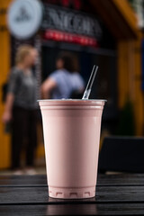 Plastic glass of tasty strawberry milkshake take away