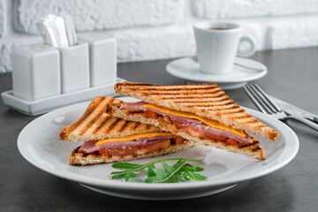toast with ham, cheese and tomato for breakfast with coffee