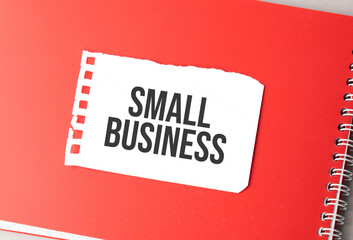 The word Small Business on torn paper on red notepad,.