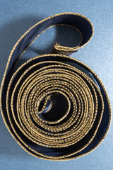 luxurious navy blue and gold ribbon with lines and checkered pattern on paper background