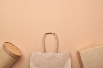 Paper packaging on a beige background. Food delivery, takeaway food. Environmental protection. Zero...