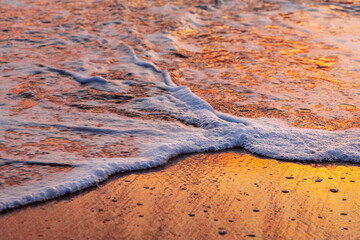 Sandy beach with sea foam